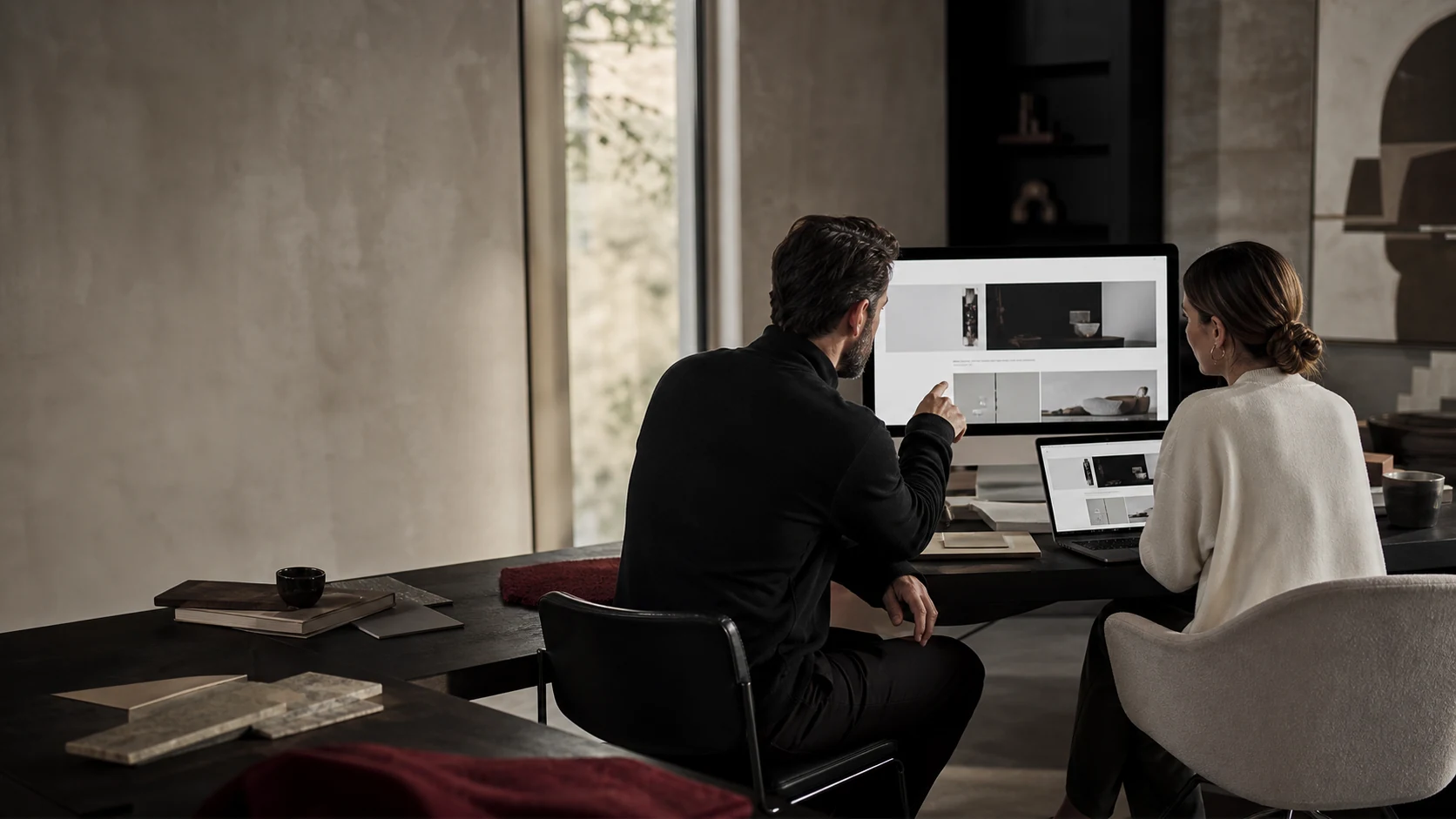 Ein Unternehmer und eine Designerin besprechen eine individuell entwickelte Website.